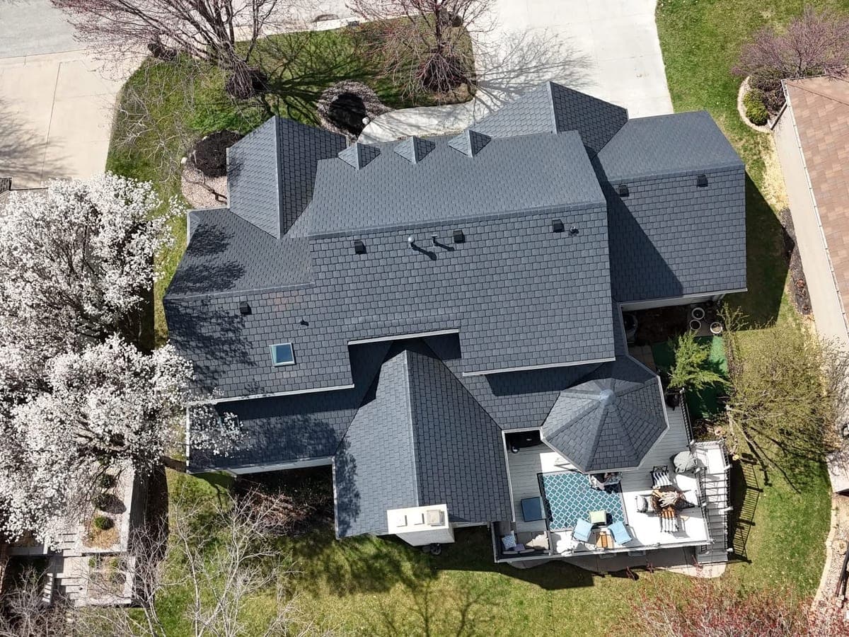 Aerial view of a completed dark-gray shingle roof on a large home