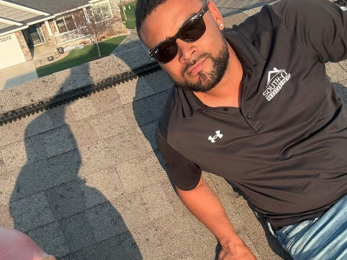 South O Roofing crew member in a branded polo on an asphalt shingle roof